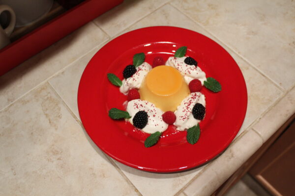 Flan - Vanilla custard marinated in fresh caramel sause accented with berries and a maple vanilla whipped cream